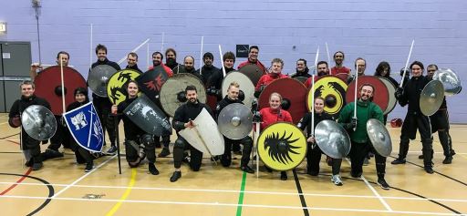 The Academy of Historical Fencing posing with mixed weapons and shields.